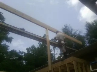 Carpenter setting a ridge beam over a new addition frame — Ice Dam Removal by Roofing Brothers in Breckenridge