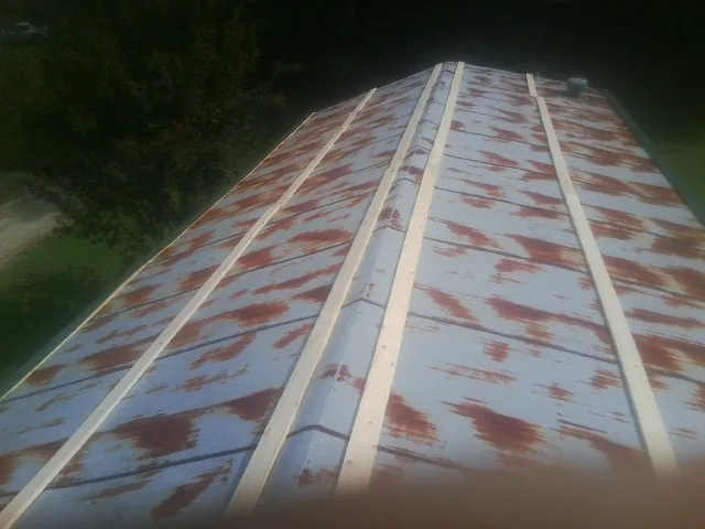 Rusted metal roof panels with new wood purlins before replacement — Storm Damage Roof Repair in Breckenridge by Roofing Brothers